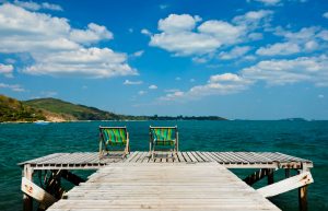 Sessel auf Holzdeck mit Sicht auf's Wasser